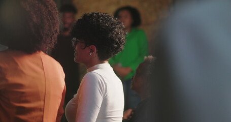 Speaker delivering powerful message to congregation, holding microphone, wearing vibrant pink...