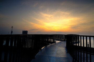 Obraz premium Serene Sunset Over Water A Walkway to Tranquility