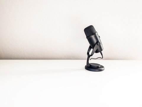 Modern podcast microphone on white desk