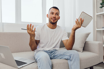 Smiling man engaged in brainstorming ideas at home, wearing casual clothes and expressing creativity. A modern workspace highlights productivity and inspiration.