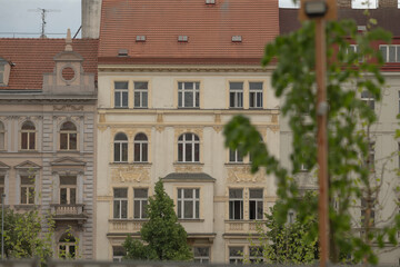 The captivating image showcases a variety of historical architecture prominently featuring residential buildings surrounded by lush greenery, all set within a vibrant urban environment