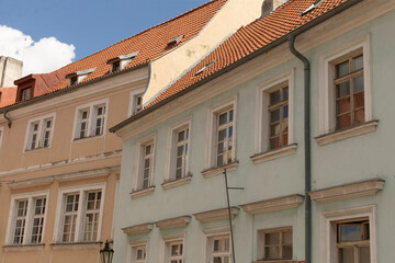 The photo captures stunning historic buildings featuring colorful facades, with visible windows and charming red roofs all set against a clear blue sky that enhances the scenes beauty