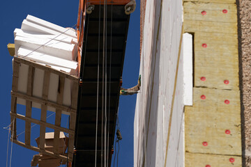 Insulating the facade of a multi-storey building with quartz wool and expanded polystyrene.  Fixing...