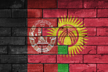 colourful painted big national flag of afghanistan and flag of kyrgyzstan on a massive old brick wall background. concept