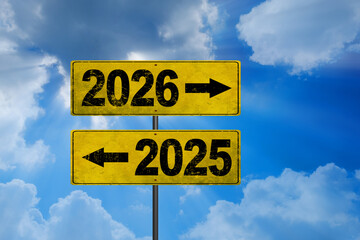 Road signs indicate the path to the new year 2026 and the old year 2025 on a blue sky, creative idea. Choose a new road, concept. Change for the better
