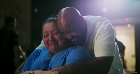 Person of African descent embraces woman in emotional moment of joy and laughter, tender hug,...
