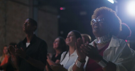 Congregation clapping and worshiping during evangelical church service, Afro-descendant woman with joyful expression, glasses, vibrant hair, and jewelry, community celebration of faith