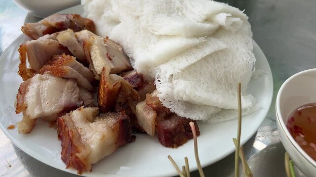 pressed rice noodles Vietnamese food lots of greens fish sauce meat with lard pork rice cakes 