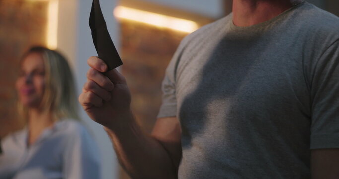 Man with red beard raising offering envelope during worship in church, illuminated cross on wall, spiritual devotion, symbolic act of giving, peaceful and joyous expression