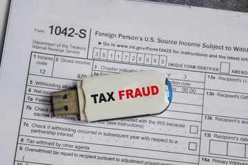 USB drive with text tax fraud and tax form. Business and finance concept
