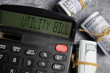 Dollar bills and calculator with text utility bill. Business and Financial conceptual