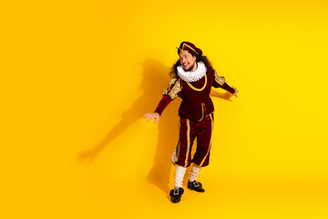 Portrait of a male performer in a medieval costume on vibrant yellow backdrop
