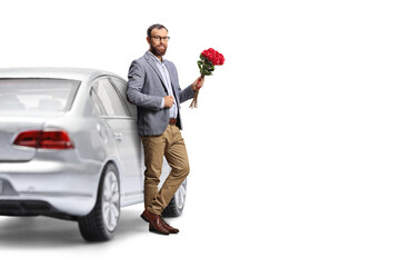 Man leaning on a car and holding a bunch of red roses