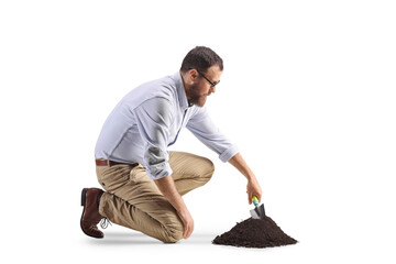Man digging a pile of earth with a spade