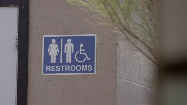 This video features a clear view of an inclusive restroom sign, welcoming men, women, and individuals with disabilities into a shared, accessible facility. 