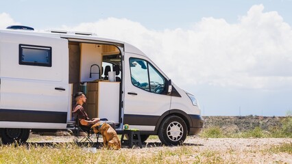 Man relaxing with dog in camper van at gorafe, spain
