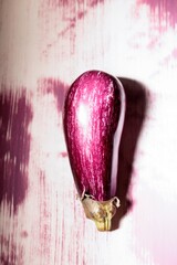 Bright graffiti artwork portrays a striking eggplant against a textured, colorful wall. This creative expression captures the intersection of art and urban life in a lively city