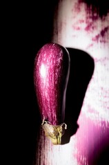 Bright purple eggplant graces an urban wall, showcasing stunning graffiti artistry. This artwork highlights the creative spirit of the neighborhood, merging natural beauty with street culture