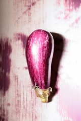 A striking graffiti eggplant stands as a focal point in a lively alley, its vivid colors contrasting against the textured backdrop. This unique piece captures the essence of urban creativity