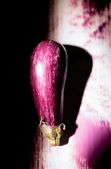 Colorful graffiti artwork vividly depicts an eggplant on a city wall at dusk, enhancing the urban landscape with its quirky charm and creativity. The piece draws in passersby with its charm