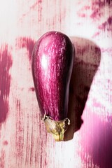 Bright eggplant artwork on a weathered wall catches the eye, blending creativity with urban life. This stunning piece invites passersby to appreciate street art's lively expression