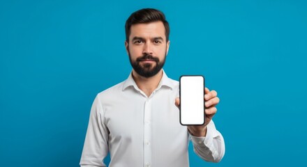 Businessman displaying smartphone with blank screen on blue background for technology presentation or advertisement