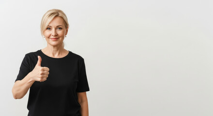 Middle-aged woman smiling with a positive mood showing thumbs up on a copy space background
