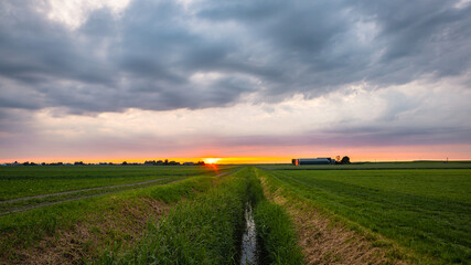 Sunset sky over a small long ditch in the Dutch countryside