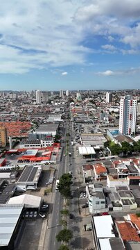 Cidade de m&eacute;dio porte cercada por &aacute;reas verdes, com bairros residenciais e edif&iacute;cios. Imagem ampla revela expans&atilde;o urbana