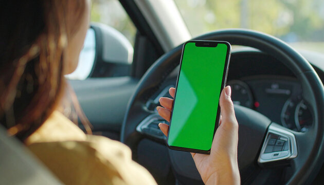 POV Close up of a woman's hand holding a mobile telephone with a vertical green screen in car chroma key smartphone technology cell phone street touch message display hand
