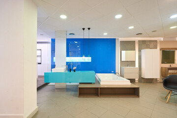 Modern bathroom furniture displayed in showroom with blue accent wall