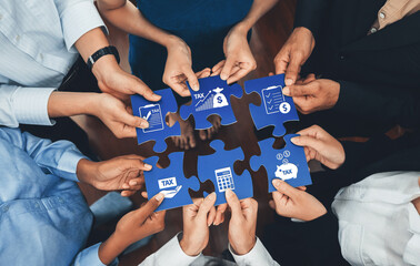 A diverse group of hands working together to connect puzzle pieces, symbolizing teamwork and...