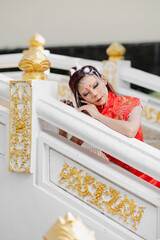 Young woman lying gracefully on white and gold balcony in traditional outfit