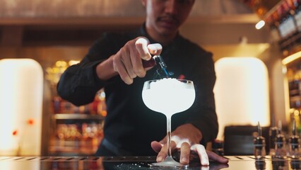 Closeup vodka cocktail with Asian bartender burning fire into sugar presentation on luxury counter bar at nightclub. Special refresh drink showcasing nightlife mixology inviting warm light. Vinosity.
