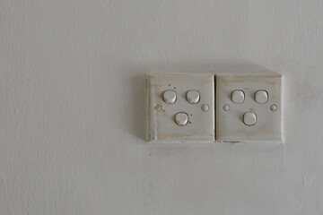 Old Dirty Light Switches on White Wall Grunge Electrical Panel Close Up White Isolated With Copy...