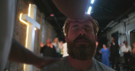 Man experiencing spiritual prayer, hand placed on head, close-up of emotional moment, religious...