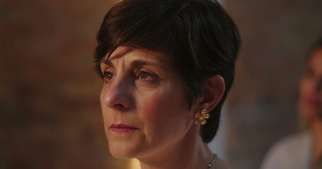 Close-up of woman with short hair, nodding in affirmation, paying attention from audience...