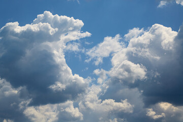 Bright sunlight on textured clouds creates sharp contrasts and volume.