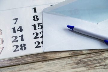 A simple pen against the background of various envelopes and a calendar close-up, mail and...