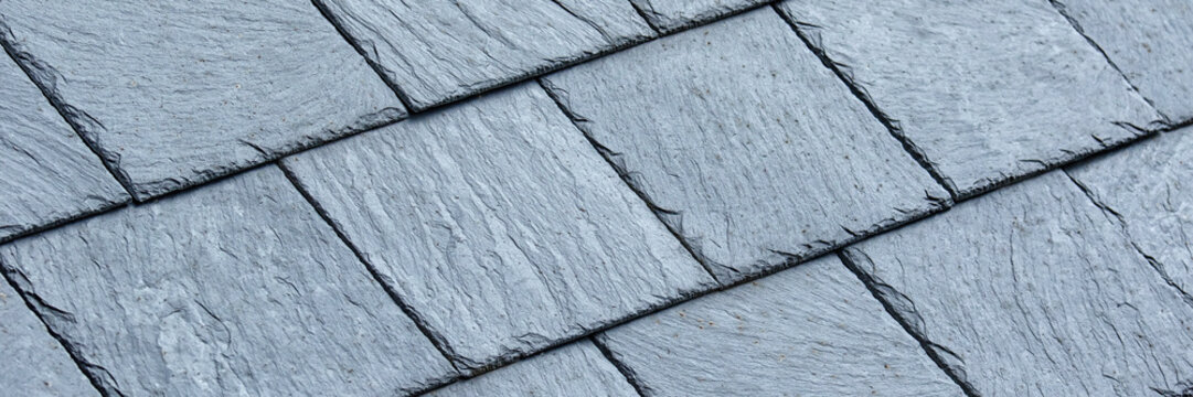 Panorama of clean grey slate roof tiles for use as a background texture
