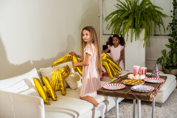 girls, Sisters joyfully embracing each other in a lush and cozy living space filled with warmth