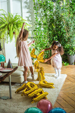 girls, Sisters joyfully embracing each other in a lush and cozy living space filled with warmth