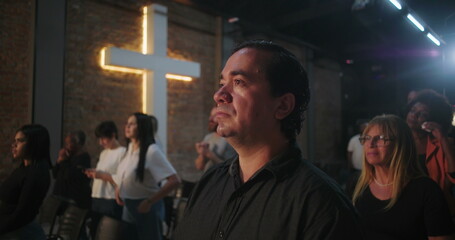 Close-up of a congregation member during a Christian event, standing in spiritual reflection with a...
