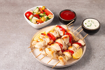Grilled chicken skewers. Satay with side lemon and salad. Kebab with sauces. 