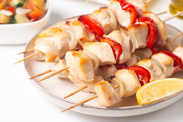 Grilled chicken skewers. Satay with side lemon and salad. Kebab with sauces. 