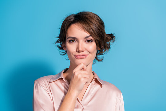 Stylish young woman posing against blue background in elegant pink satin shirt - Powered by Adobe