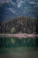 Fototapeta premium The Black Lake, Durmitor in Montenegro. The lake with crystal-clear water reflecting the stunning surrounding mountains. And Bobotov Kuk peak towers over the lake.