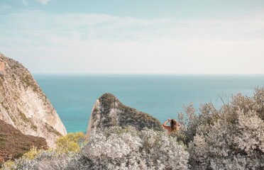 Gazing at the endless blue of the Ionian Sea, a solitary figure takes in the stunning cliffs and tranquil waters of Zakynthos. Summer warmth fills the air, inviting exploration and serenity