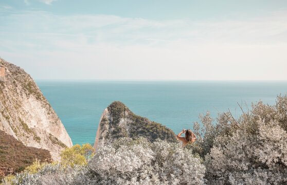 Gazing at the endless blue of the Ionian Sea, a solitary figure takes in the stunning cliffs and tranquil waters of Zakynthos. Summer warmth fills the air, inviting exploration and serenity