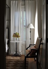 light, bright bedroom view of nightstand and bench with hydrangea